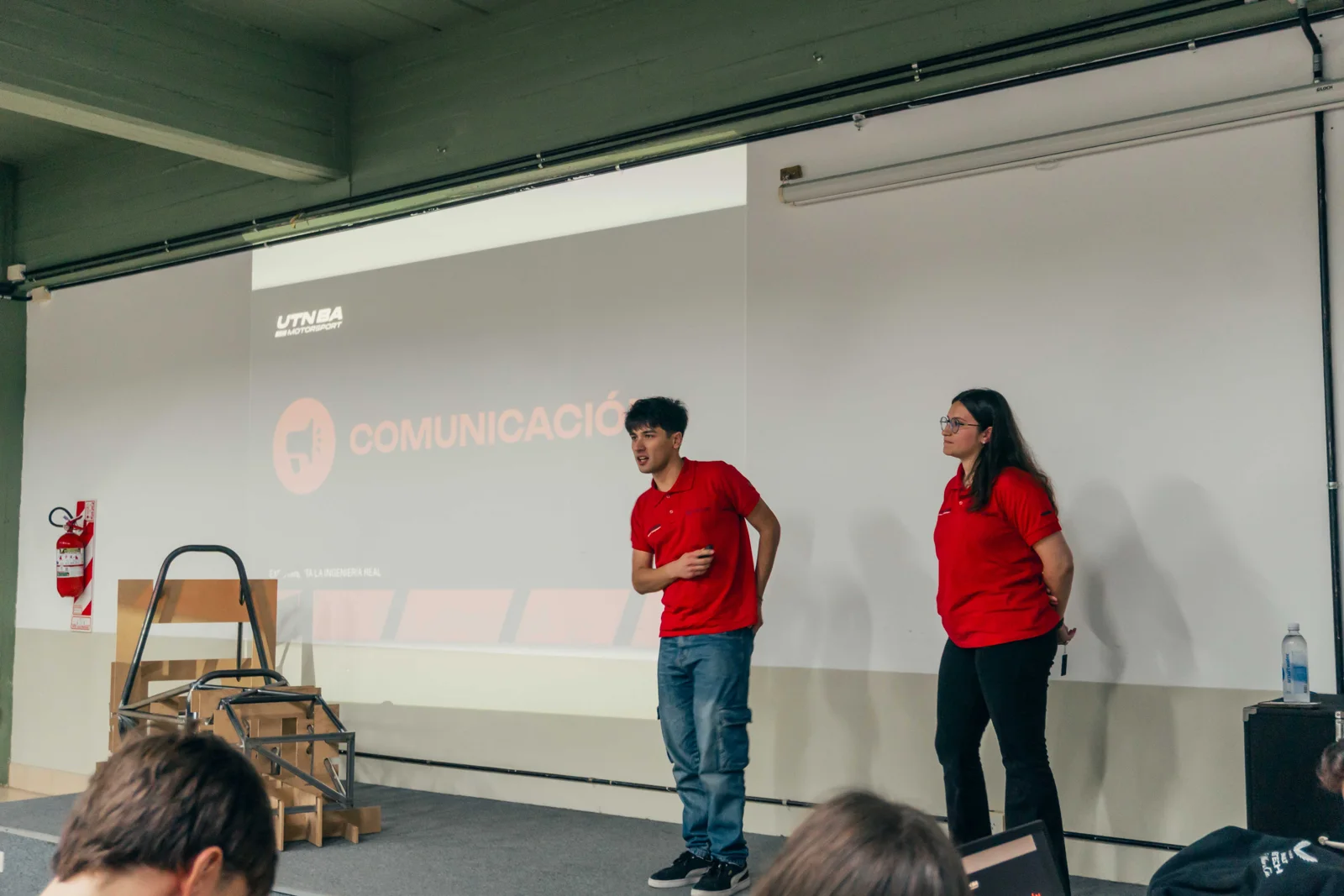 Integrantes del equipo exponen el proyecto junto al chasis.
